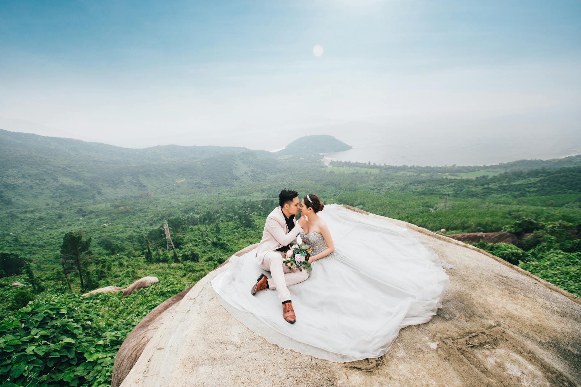 Para młoda obejmująca się na górskim szczycie z widokiem na Da Nang