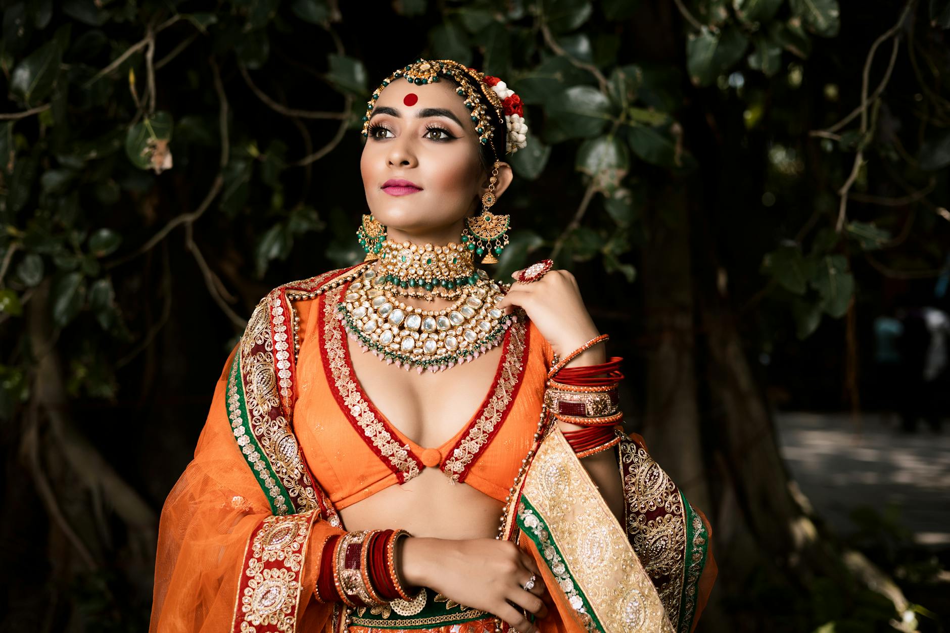 Drugi zestaw na wesele: kiedy warto przebrać się po ślubie Panna młoda w indyjskim stroju ślubnym pozuje w ogrodzie