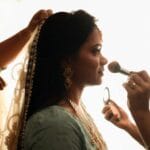 Panna młoda w tradycyjnym indyjskim stroju podczas wykonywania makijażu