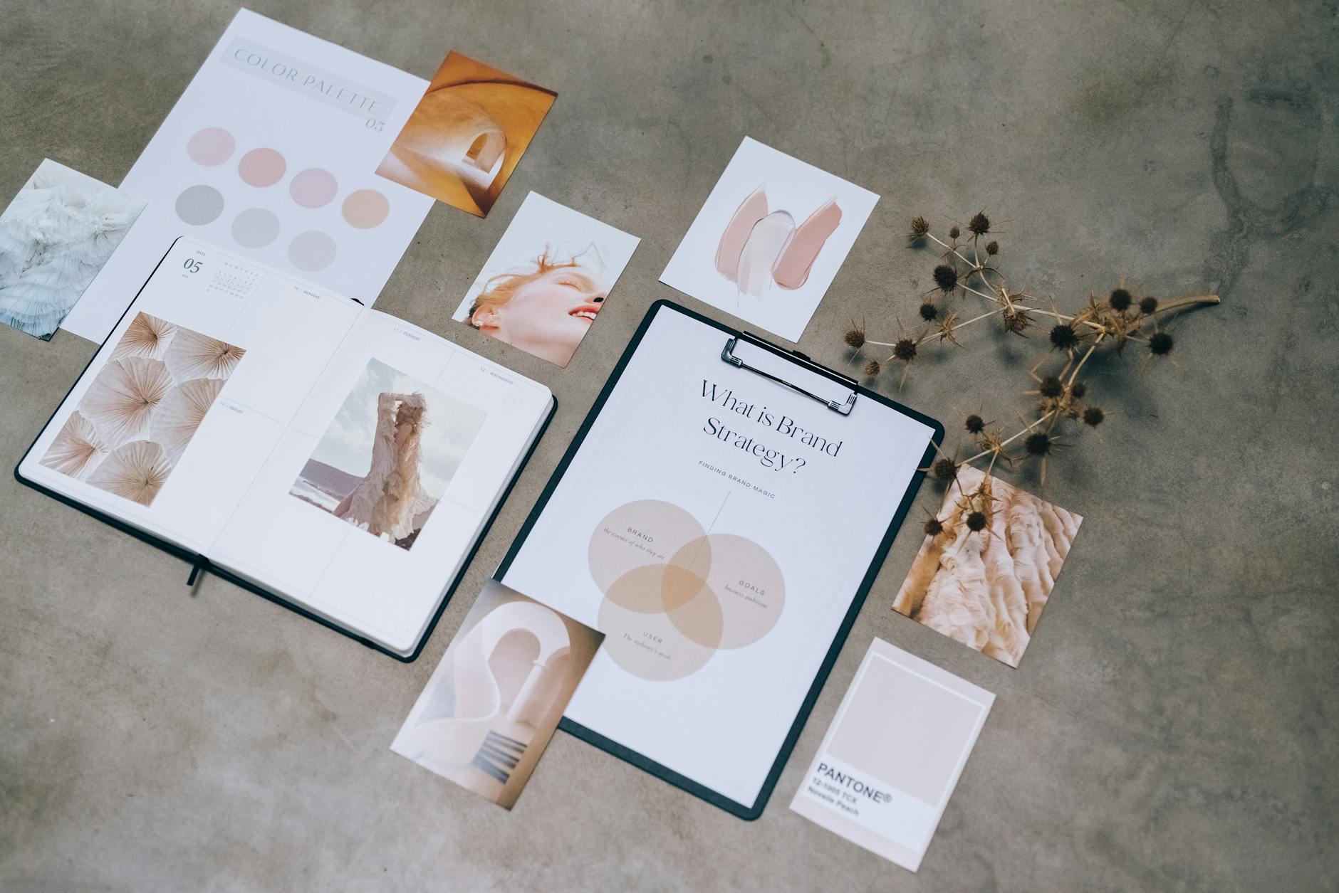 Papierowy moodboard ślubny z próbkami kolorów i notatkami na biurku