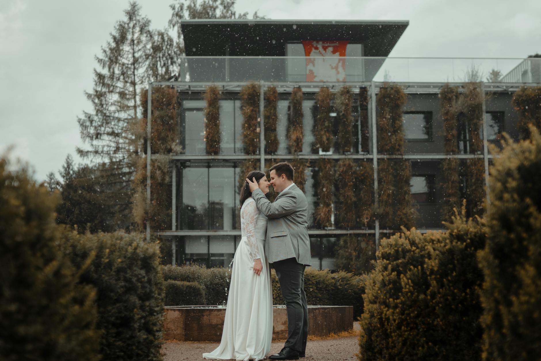 Plan B na deszcz: organizacja ślubu plenerowego bez paniki Para młoda obejmuje się w deszczu podczas ślubu plenerowego