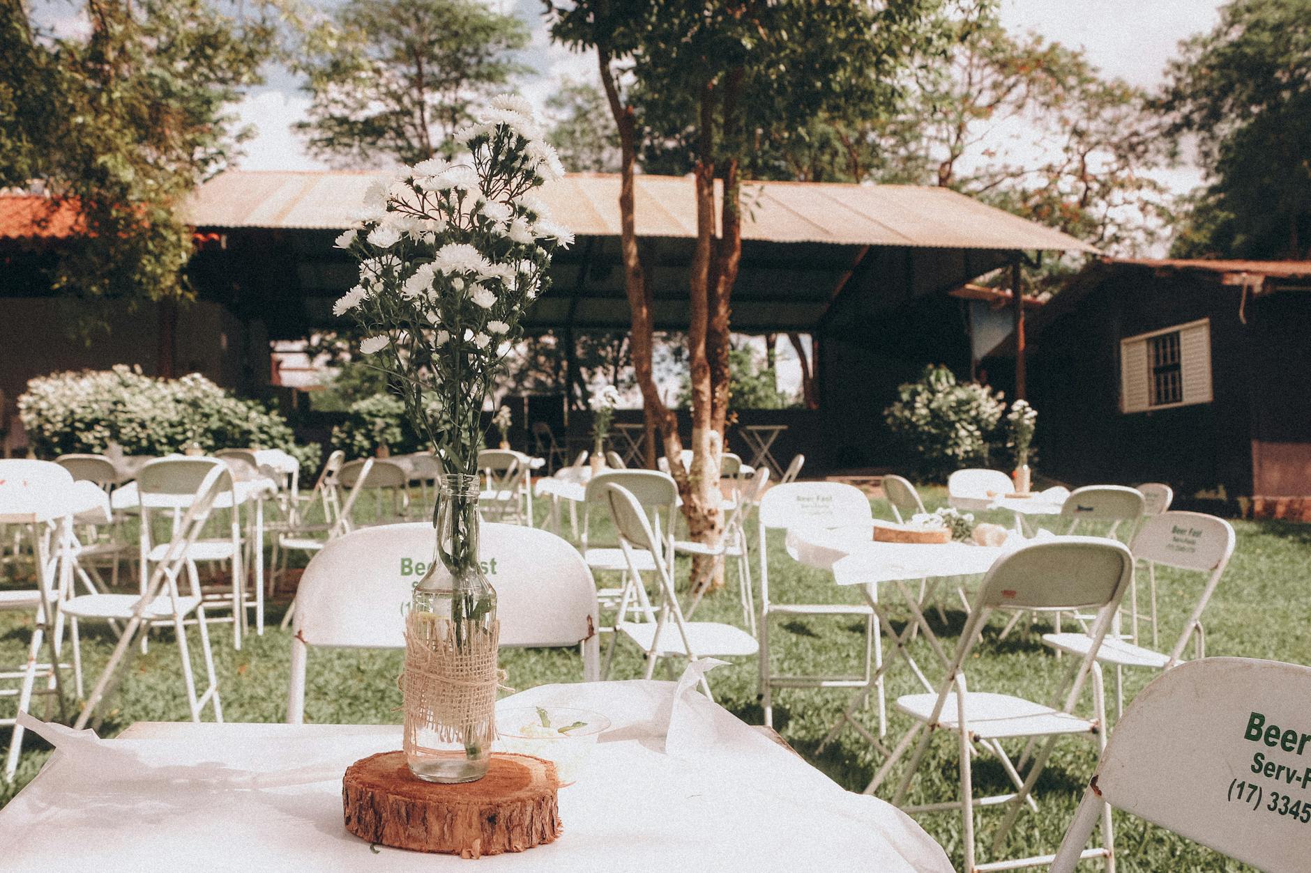 Jak ustawić ceremoniał w plenerze: wejście pary, muzyka i kolejność Plenerowy wystrój ślubny w ogrodzie z kwiatową dekoracją stołu