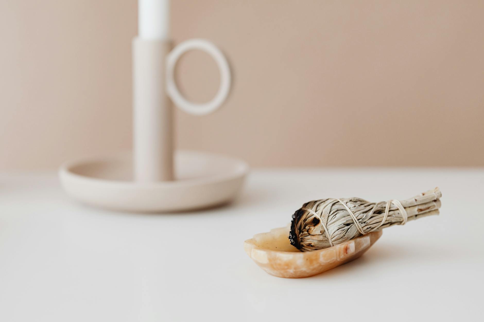 Dekoracje w kolorze szałwii i beżu: jak je łączyć, by nie wyszło „mdło” Minimalistyczna dekoracja ślubna w kolorze szałwii z świecznikiem na białym stol