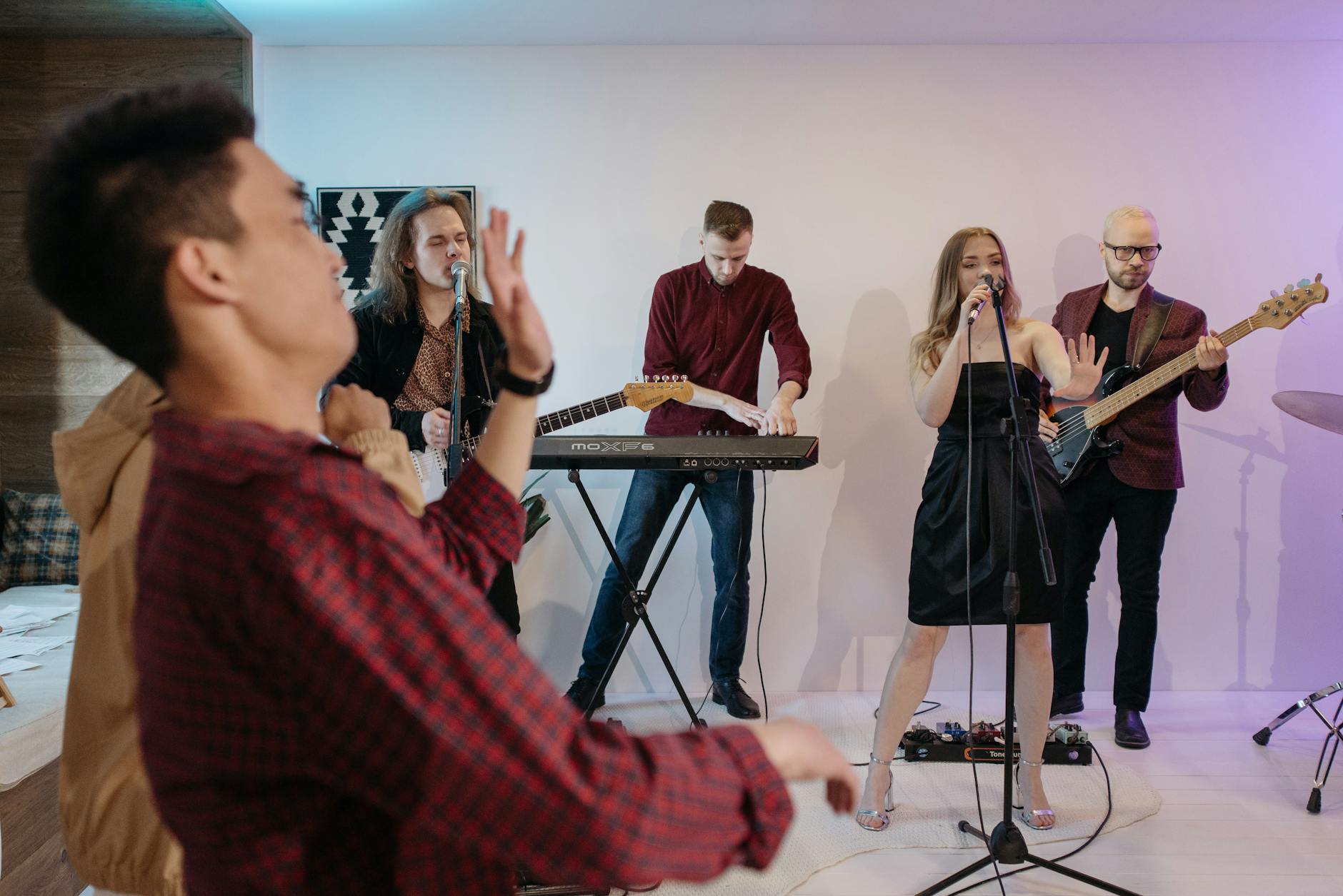 Zespół muzyczny gra na scenie w sali pełnej weselnych gości